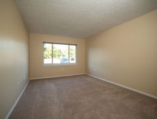 An empty spare bedroom with a large open window