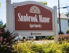Sunbrook Manor directions sign with colorful bushes